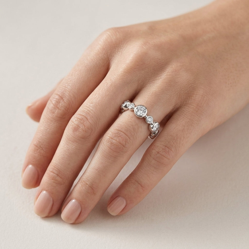 Model wearing round cut lab grown diamond bezel set alternating bubble eternity band ring.