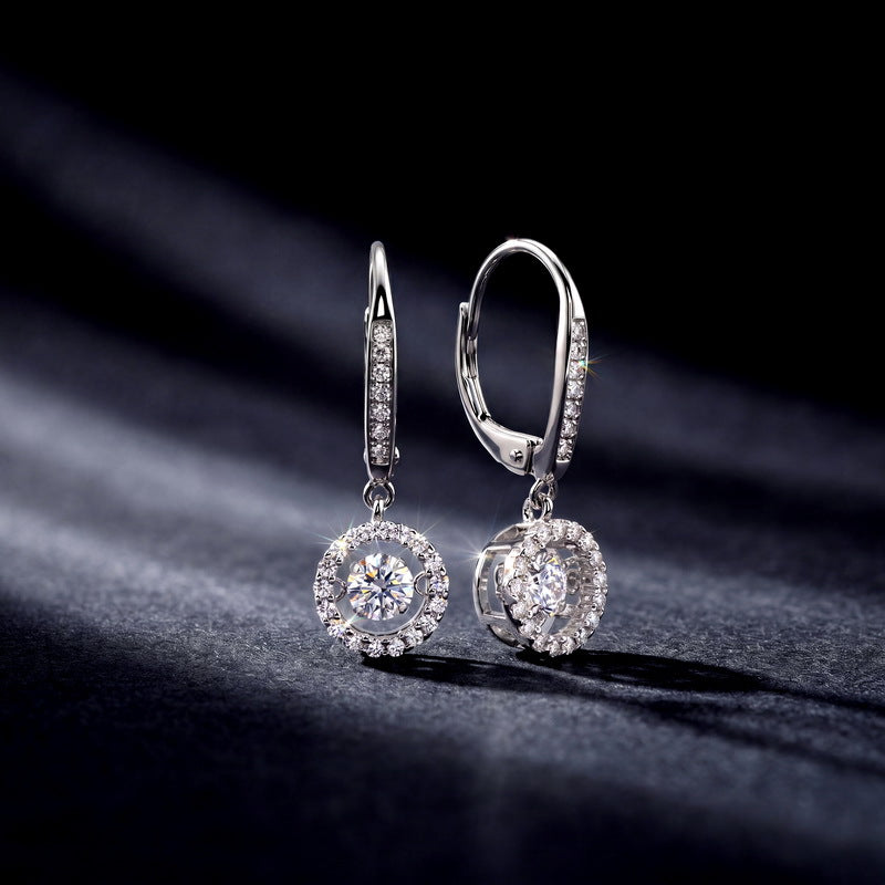 Studio lighting close-up of round lab diamond circle halo dangle earrings on dark background.