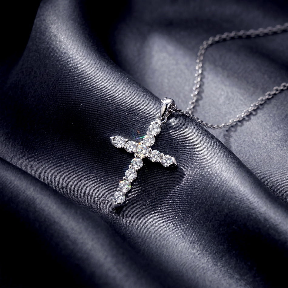 Angled profile view of round cut lab diamond classic cross pendant necklace on dark silk.