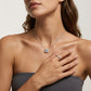 Model wearing round lab grown diamond cushion halo pendant necklace on collarbone.