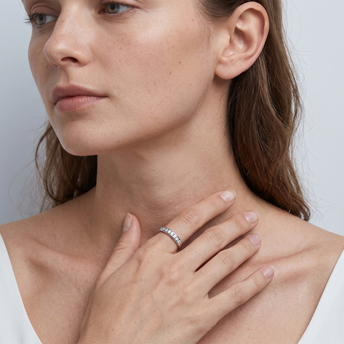 Model wearing round lab-grown diamond channel set wedding band ring.