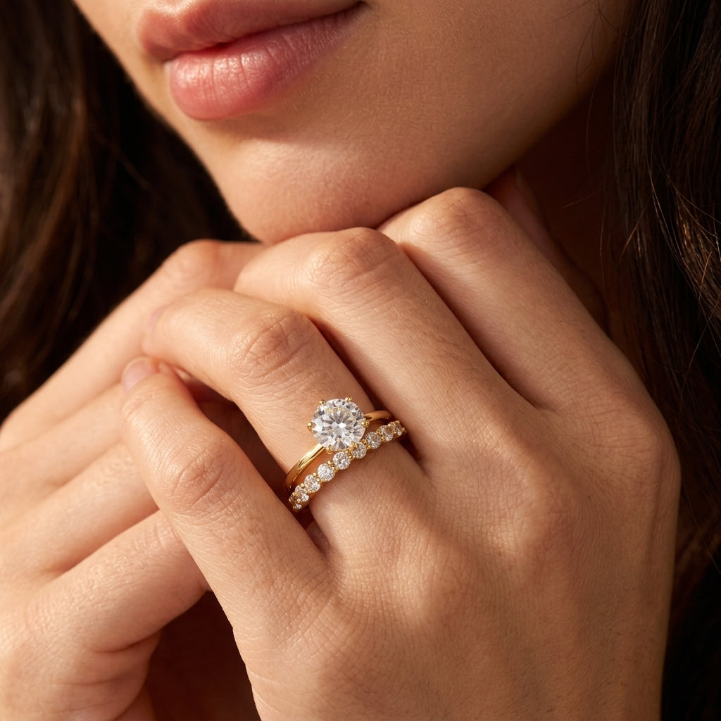 Model wearing round brilliant moissanite 6 prong crown solitaire with shared prong bubble band.