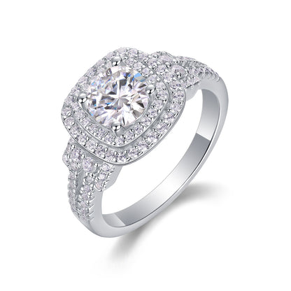 Round cut moissanite double halo engagement ring with cushion frame and split pave band on white background.