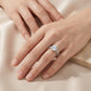 Close-up shot of a woman's hand wearing the round moissanite twisted vine ring on her ring finger.