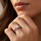 Close-up view of a model wearing round moissanite floral halo ring with twisted shank.