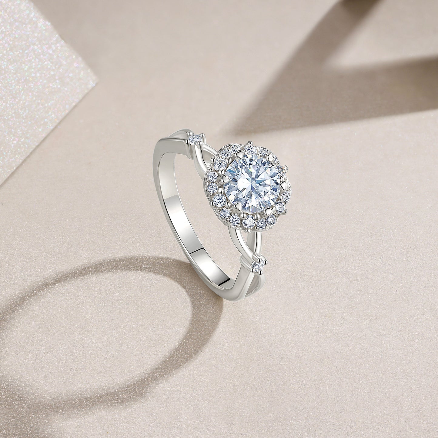 Side view of round cut moissanite floral halo ring on display.