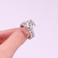 Handheld view showing hidden halo basket detail and high prong setting on round moissanite ring.