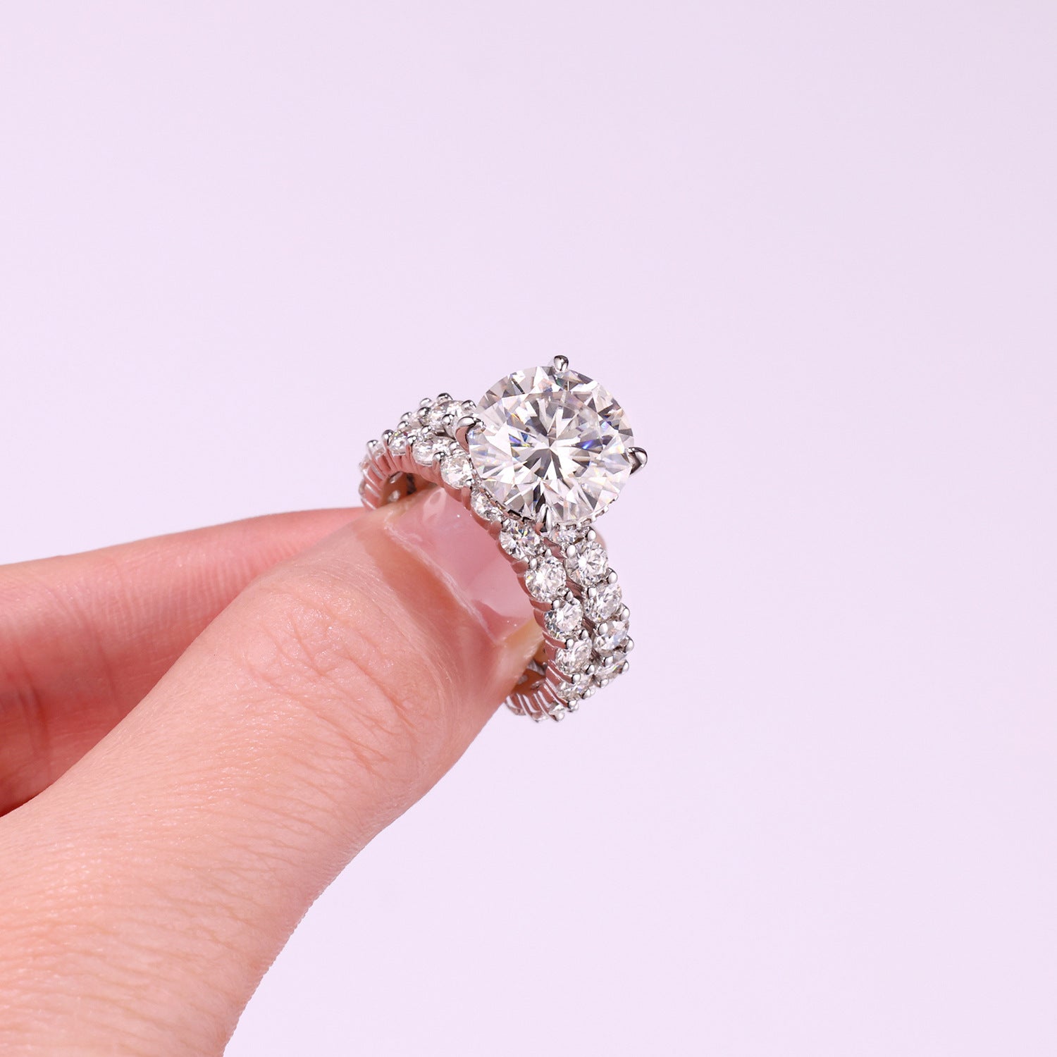 Handheld view showing hidden halo basket detail and high prong setting on round moissanite ring.