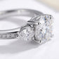 Macro view showing 4-prong basket setting and pear side stones on moissanite ring.