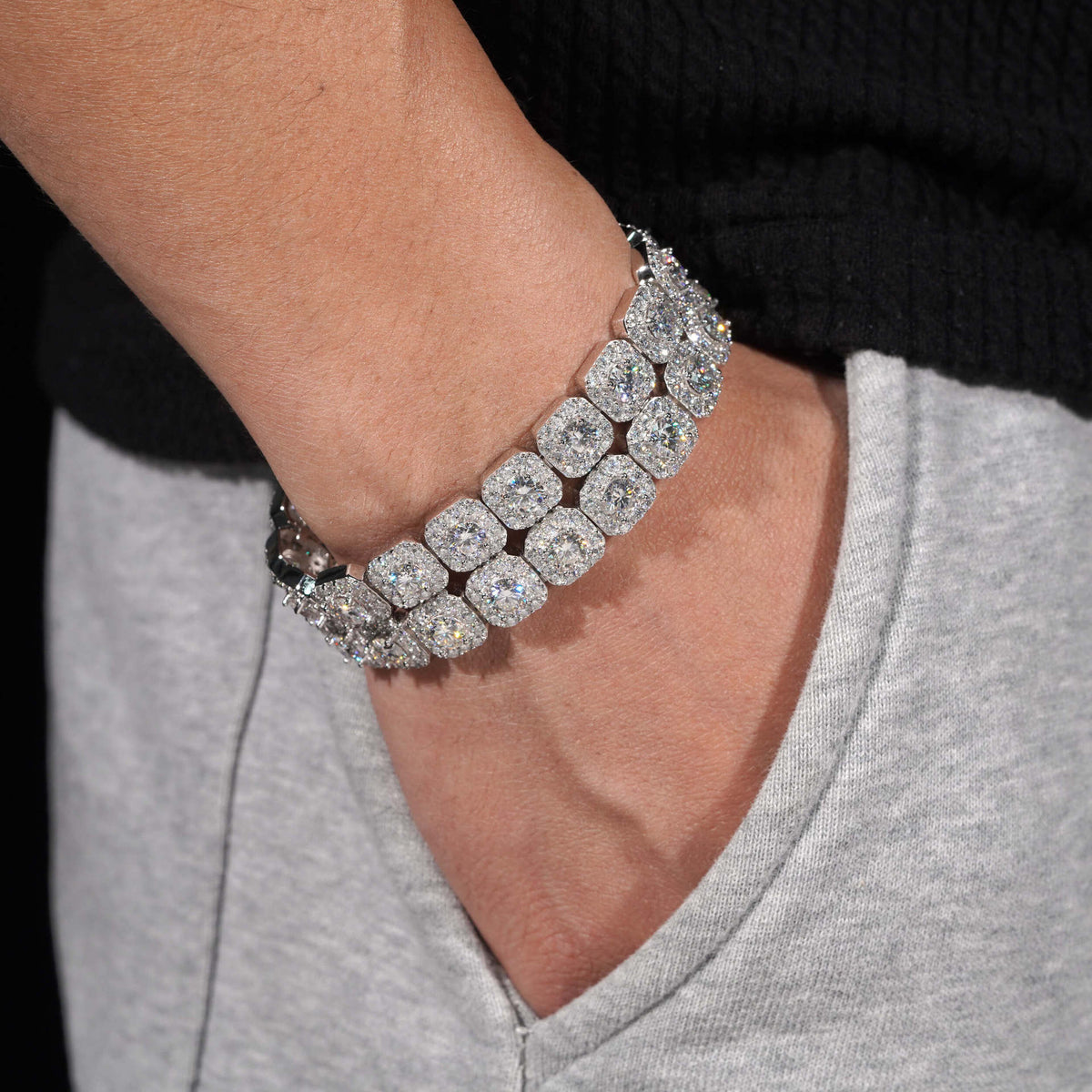Man wearing stacked round moissanite square cushion halo tennis bracelets on wrist