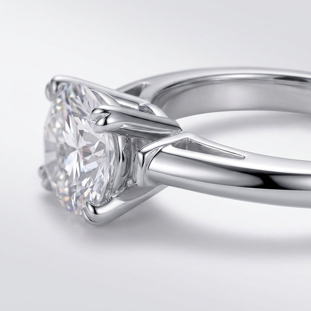Side profile view showing prong setting and tapered baguette side stones on silver moissanite ring.