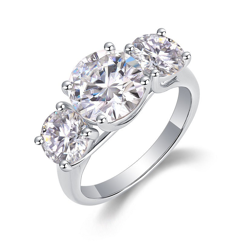 Round moissanite three stone engagement ring standing on display.