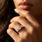 Close-up view of a model wearing round cut moissanite trilogy anniversary ring.