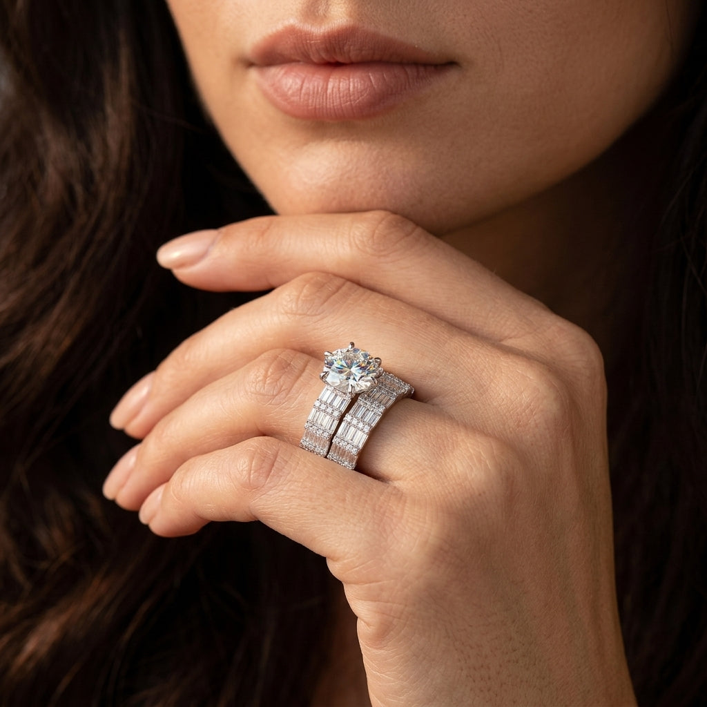 Close-up view of a model wearing luxury round moissanite ring with wide baguette stacking band.