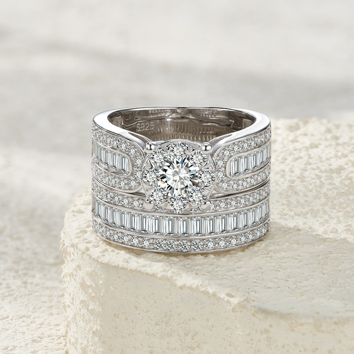 Classic silver round moissanite wide bridal set resting on a soft textured background.