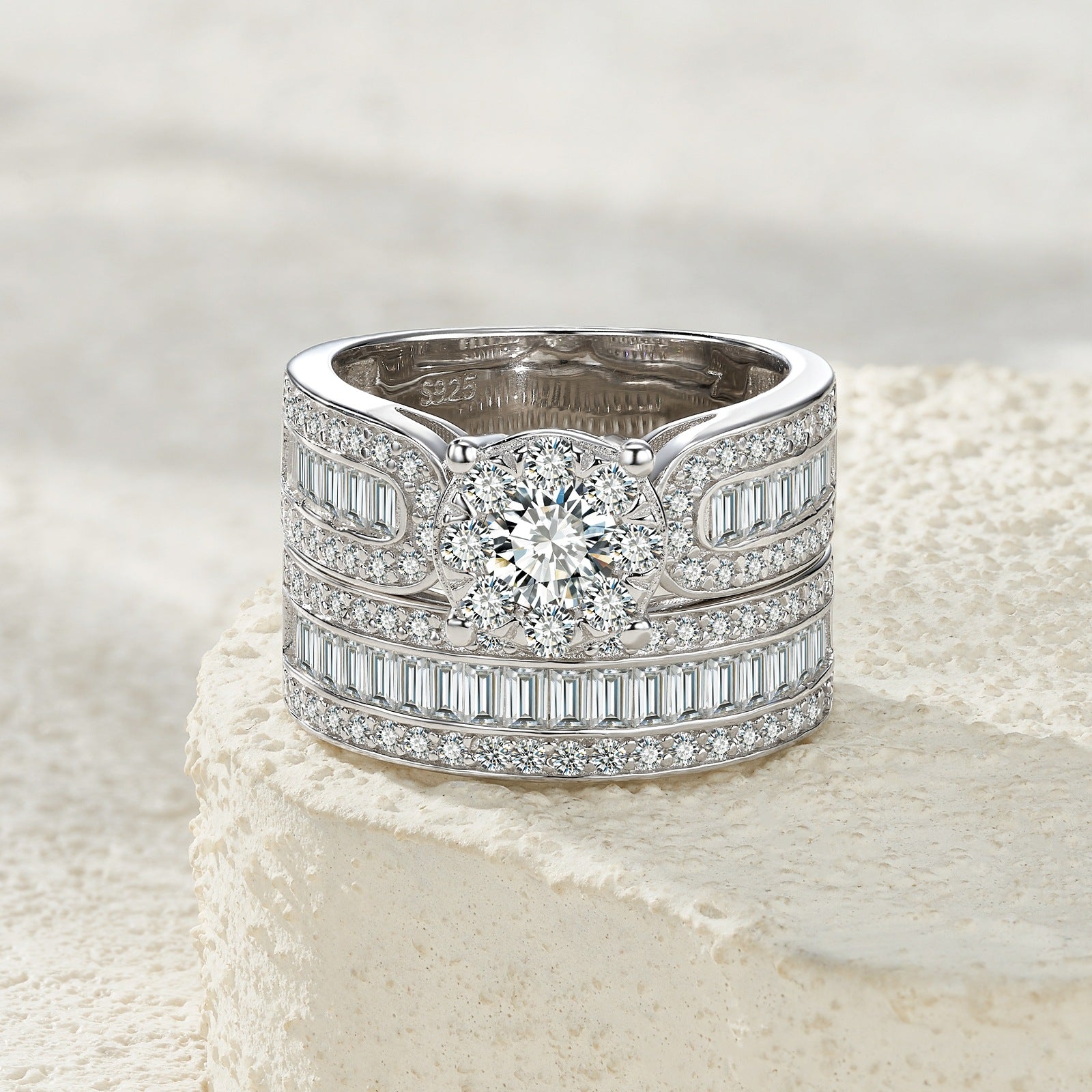 Classic silver round moissanite wide bridal set resting on a soft textured background.