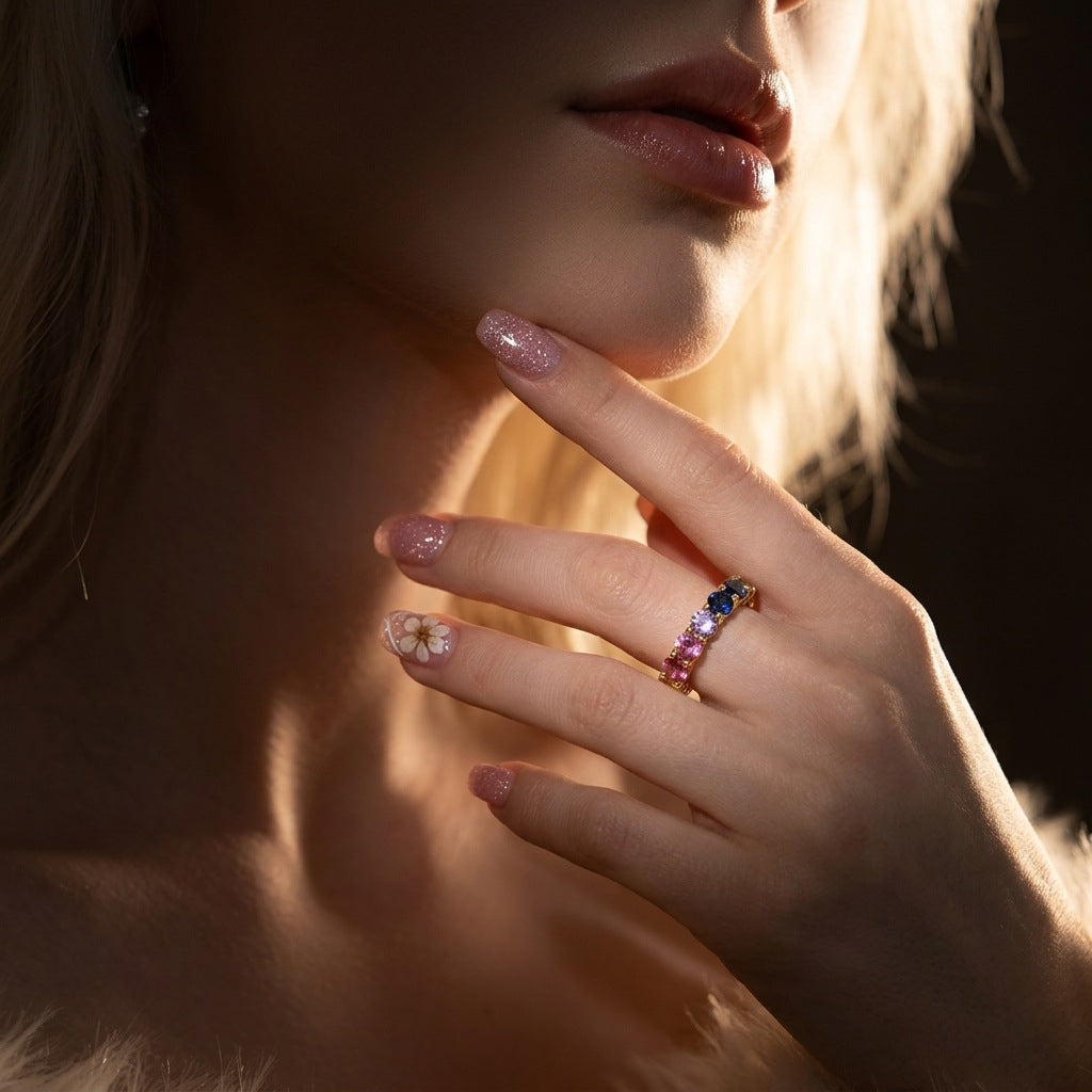Model wearing gold round rainbow gradient moissanite eternity band ring on hand