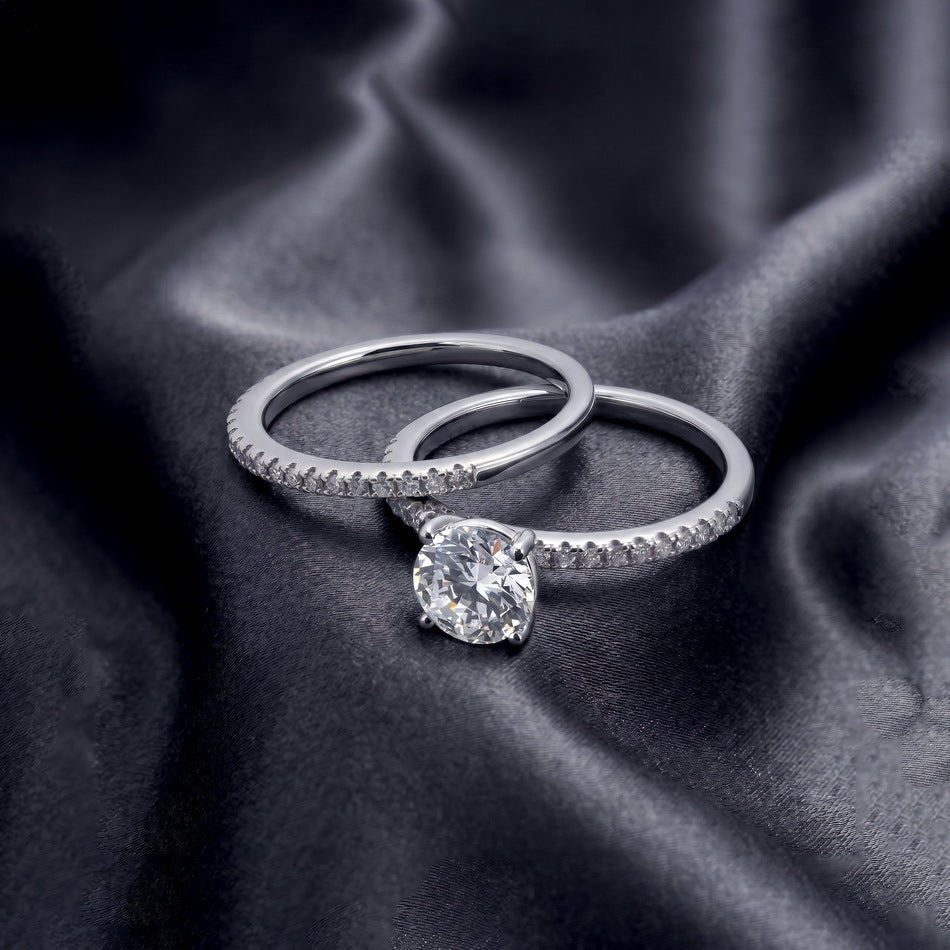 Classic round solitaire ring and matching pave band shown separately on dark silk.