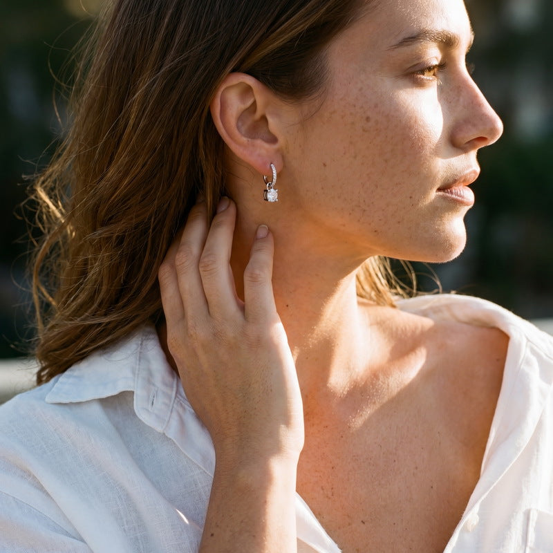 Model wearing round solitaire padlock dangle earrings with pavé huggie hoops.