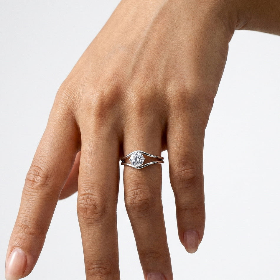 Alternative hand perspective of round brilliant swirl bypass solitaire ring.