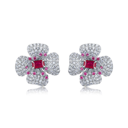 Elegant ruby four-petal flower stud earrings in gold setting for women.