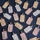 Full A-Z initial set of S925 silver iced out moissanite baguette dog tag pendants arranged in grid