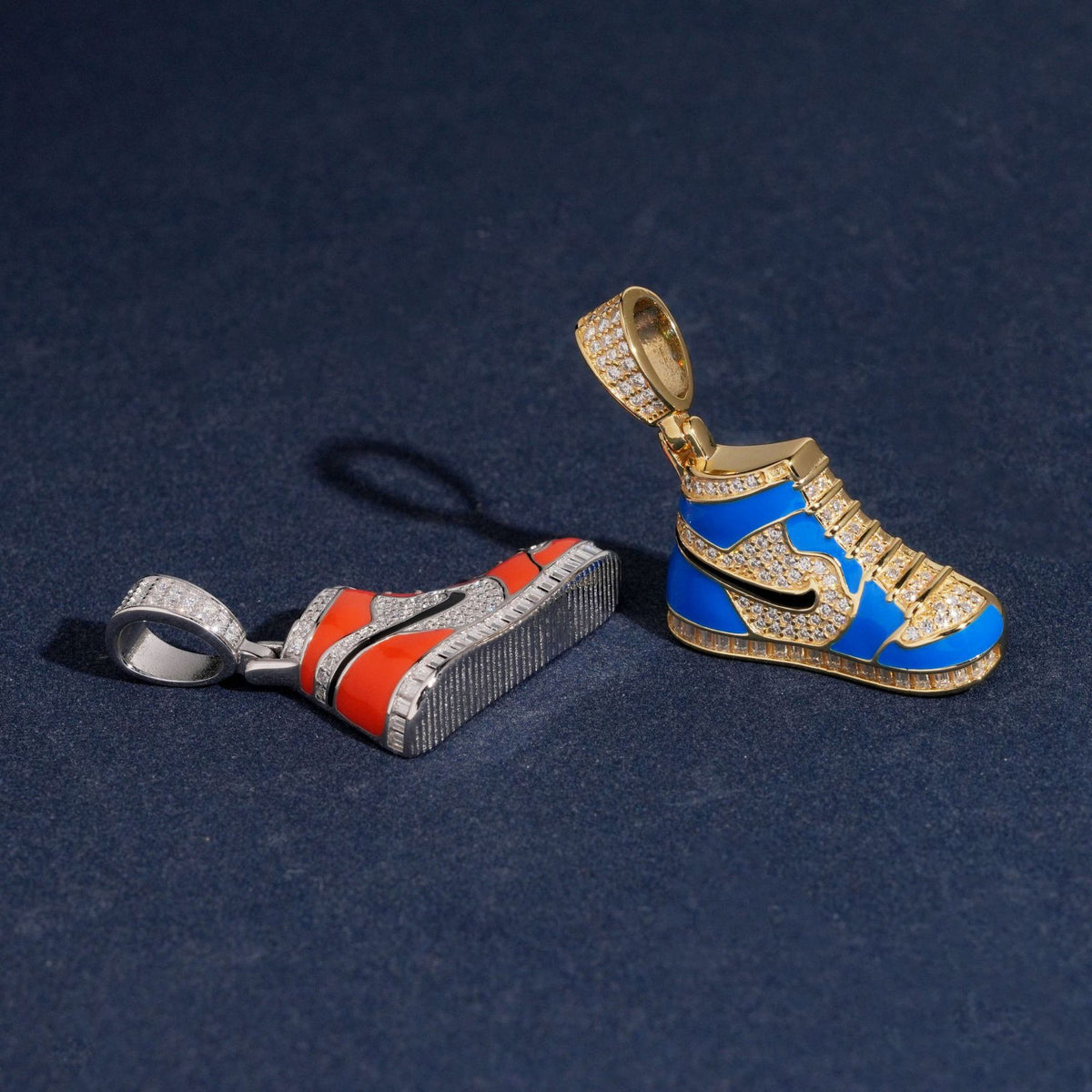Blue and orange enamel sneaker pendants showing moissanite pavé details on dark surface