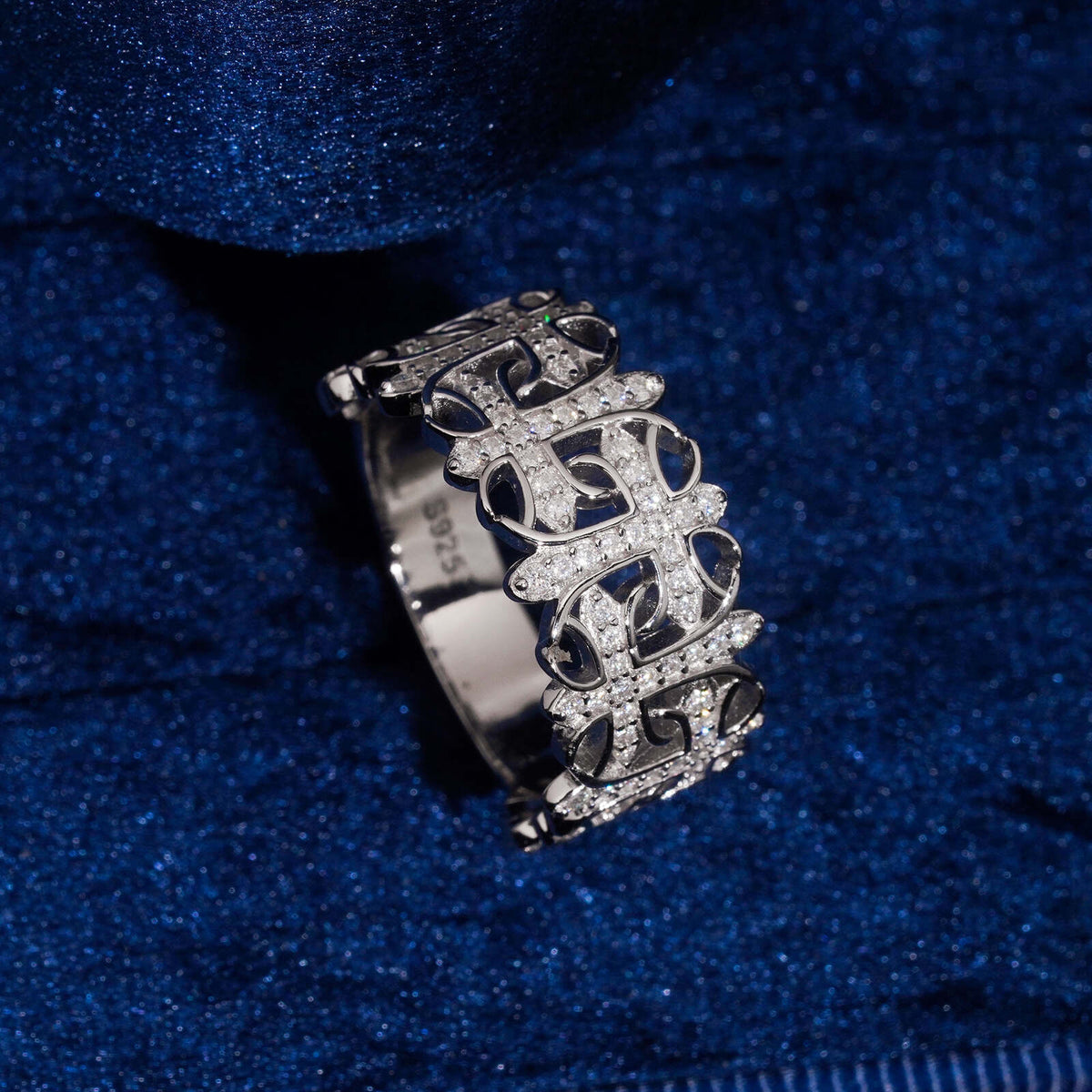 Side angle view of S925 silver moissanite gothic cemetery cross band ring on dark velvet surface   