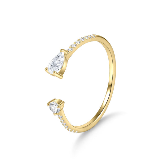 Gold ring with pear-shaped and round diamonds on a white background
