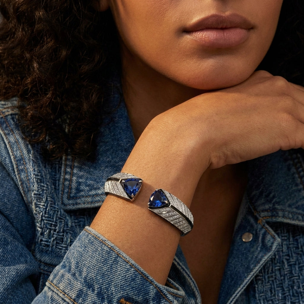 Woman wearing a silver bracelet with blue gemstones against a denim jacket.