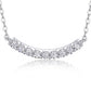 Close-up view of shared prong setting on uniform moissanite curved smile bar pendant.