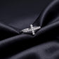 Horizontal sideways cross lab grown diamond ring resting flat on dark black silk fabric