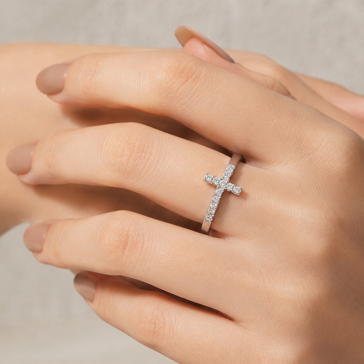 Woman wearing sideways cross lab grown diamond ring on ring finger