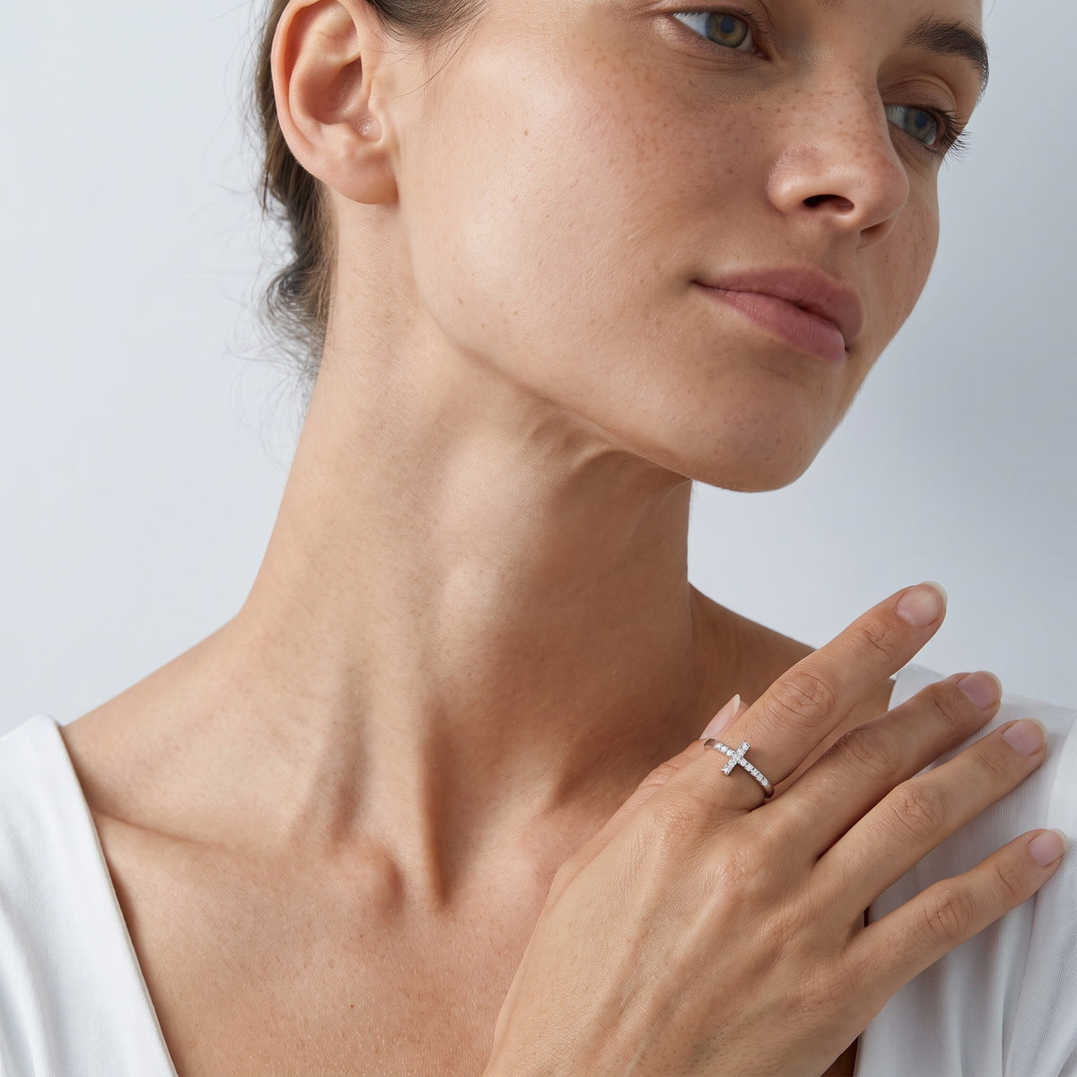 Model wearing delicate sideways cross lab grown diamond ring in lifestyle setting