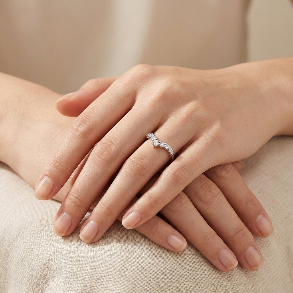 Close-up view of a model wearing silver graduated round moissanite chevron stacking ring on hand.