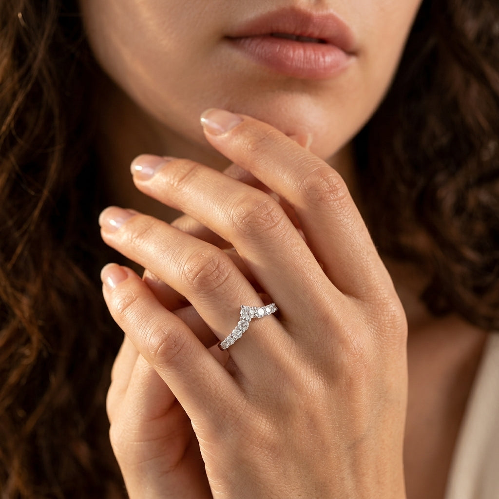 Model wearing silver graduated round moissanite chevron stacking ring in a daylight studio shot.