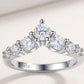 Front view of silver graduated round cut moissanite V-shaped chevron curved wedding band on white background.