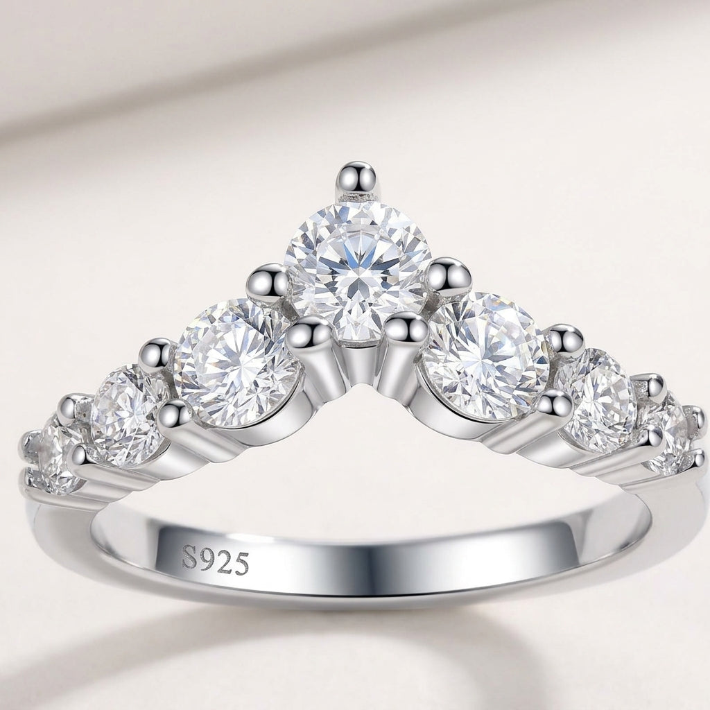 Front view of silver graduated round cut moissanite V-shaped chevron curved wedding band on white background.