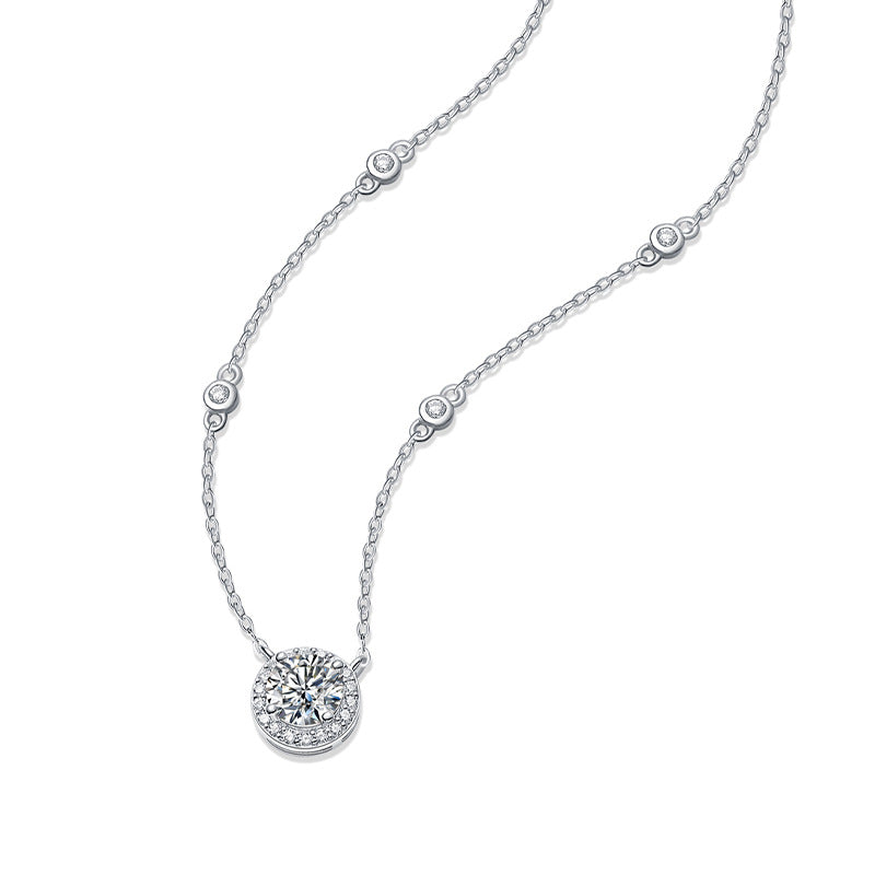 Detailed view of silver moissanite halo pendant and station chain accents.