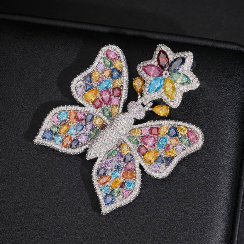 White gold S925 sterling silver iced out multi-color moissanite butterfly pendant on dark surface