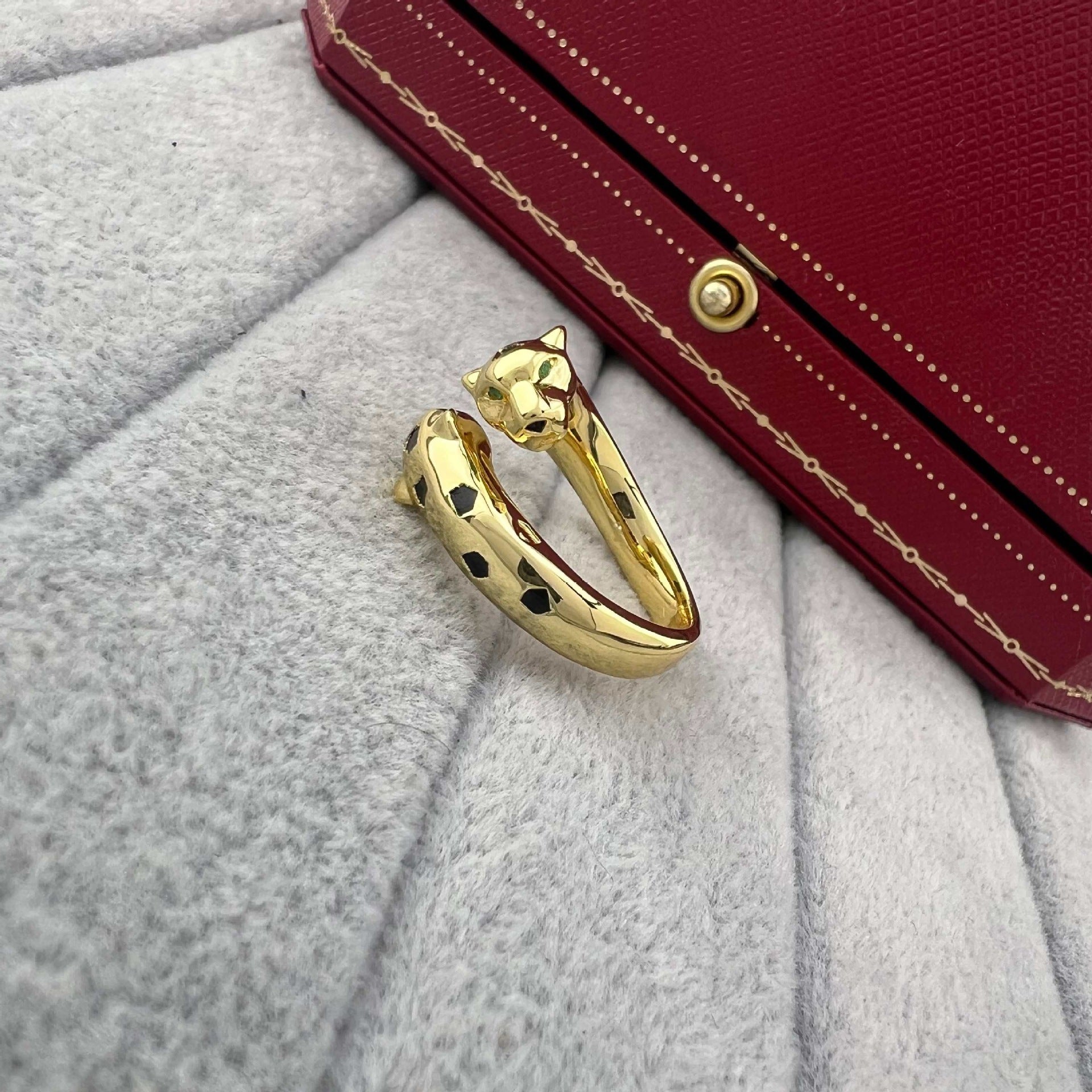 Zerra Jewelry Cartier Panthère de narrow ring with garnets and lacquer detailing, elegant gold band with intricate design.