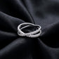 Sparkling lab grown diamond criss cross band ring resting flat on dark black silk fabric