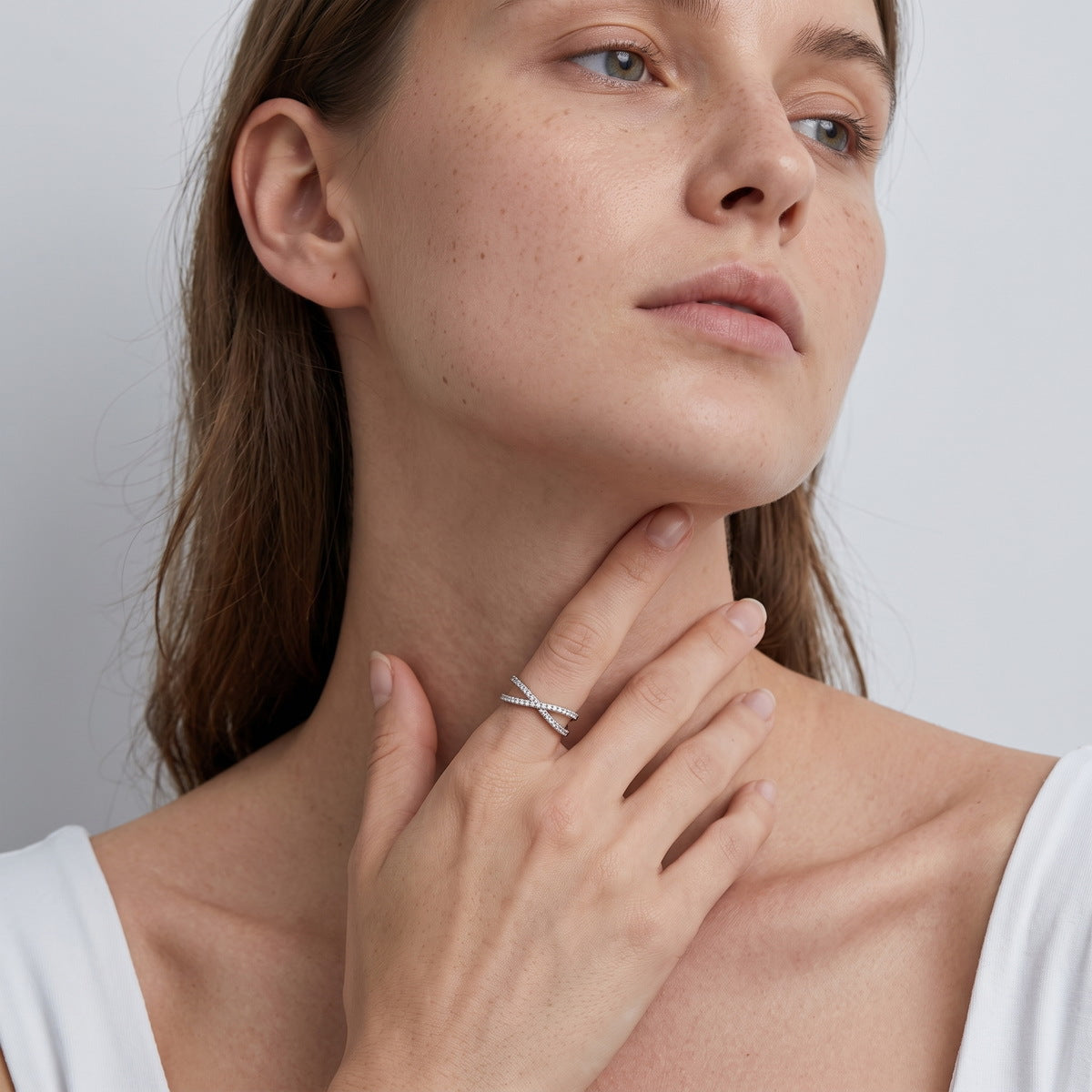 Model wearing delicate lab grown diamond criss cross x-ring in lifestyle setting