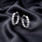 Side view profile of sparkling lab grown diamond eternity hoop earrings on black silk