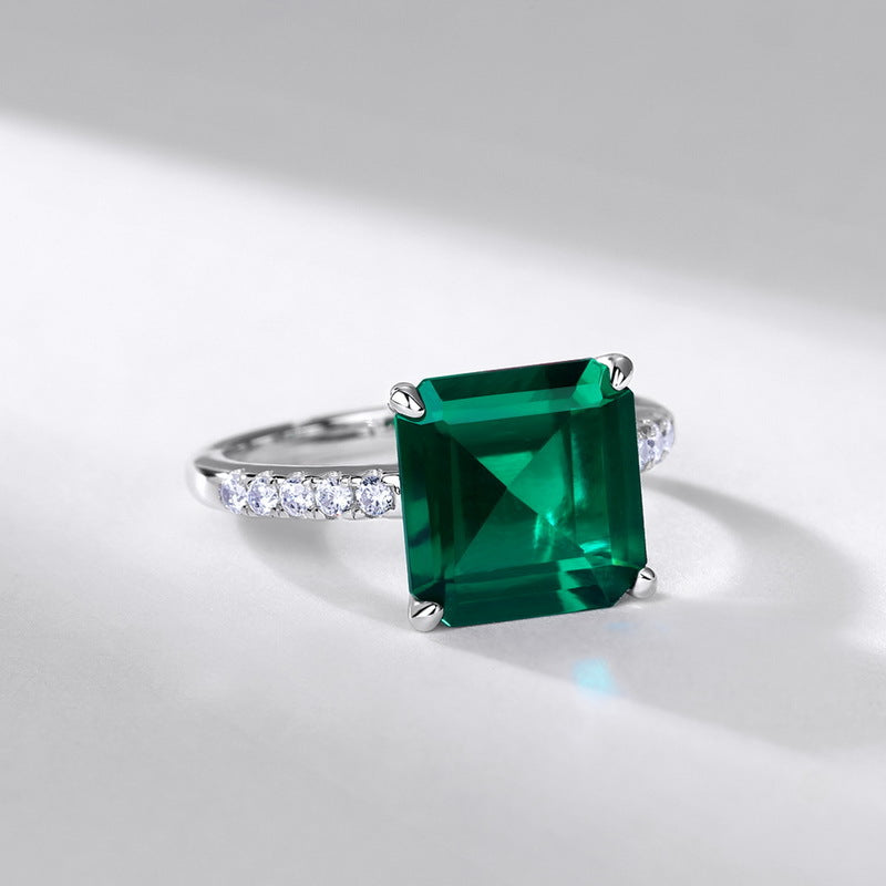 Ring with a large green gemstone on a light gray background