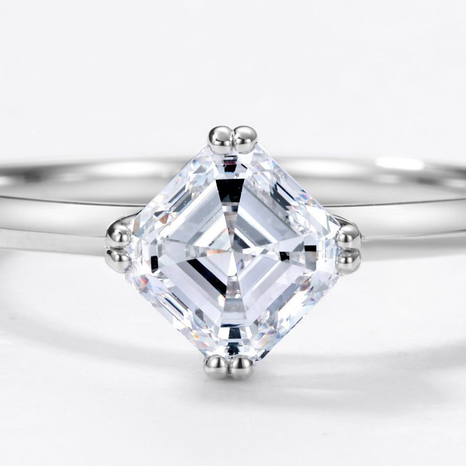 Extreme close-up shot showing square emerald step cut facets and kite setting.