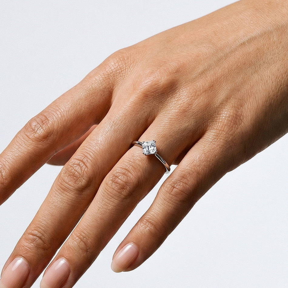 Alternative hand perspective of square emerald cut solitaire engagement ring.