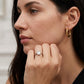 Model wearing square emerald cut solitaire engagement ring near chin.