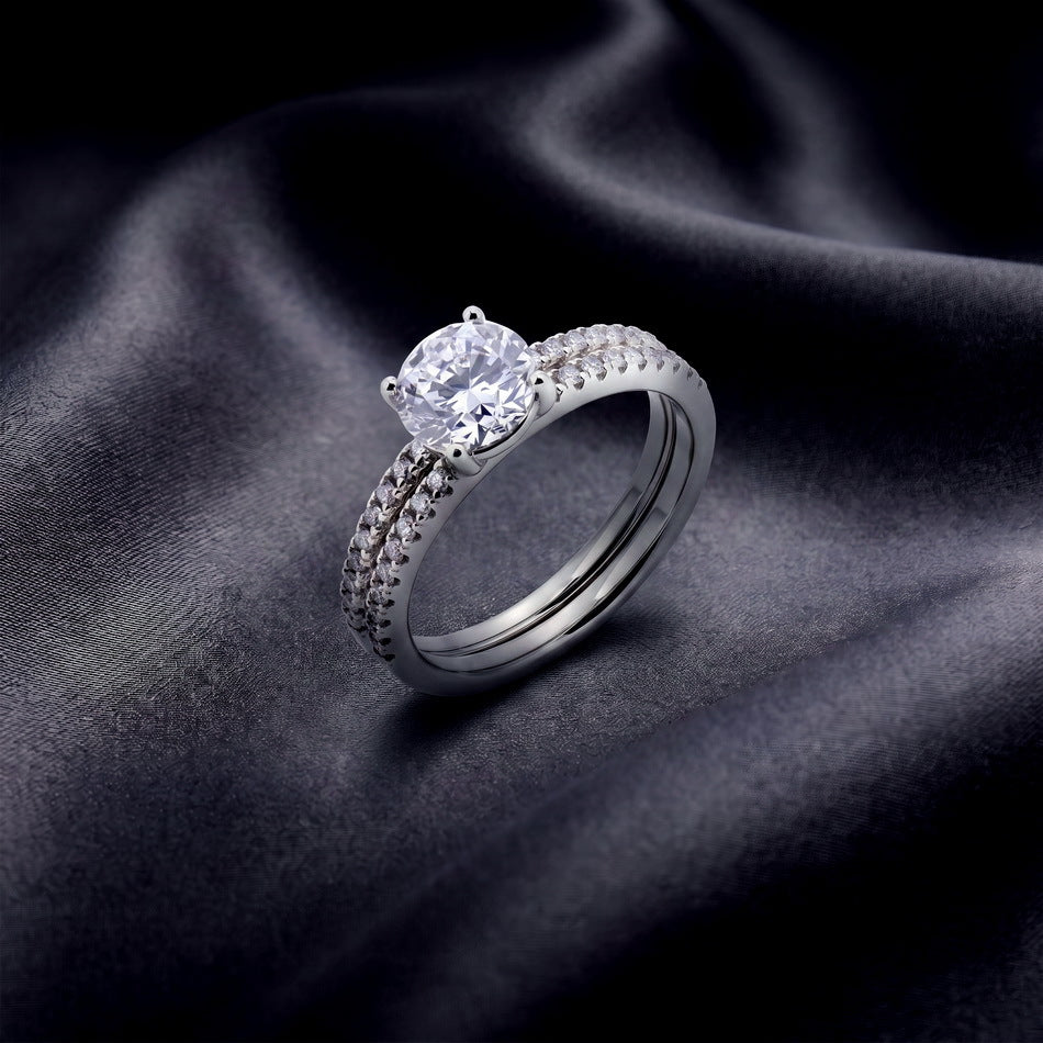 Stacked round lab grown diamond solitaire and pave wedding band set on dark silk.