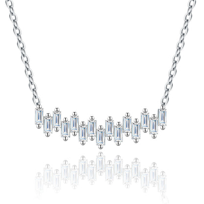 Staggered baguette cut moissanite bar necklace in sterling silver with reflection.